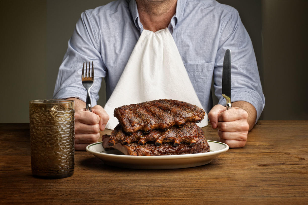 Man about to eat large stack of ribs Getty Images/RF Pictures
