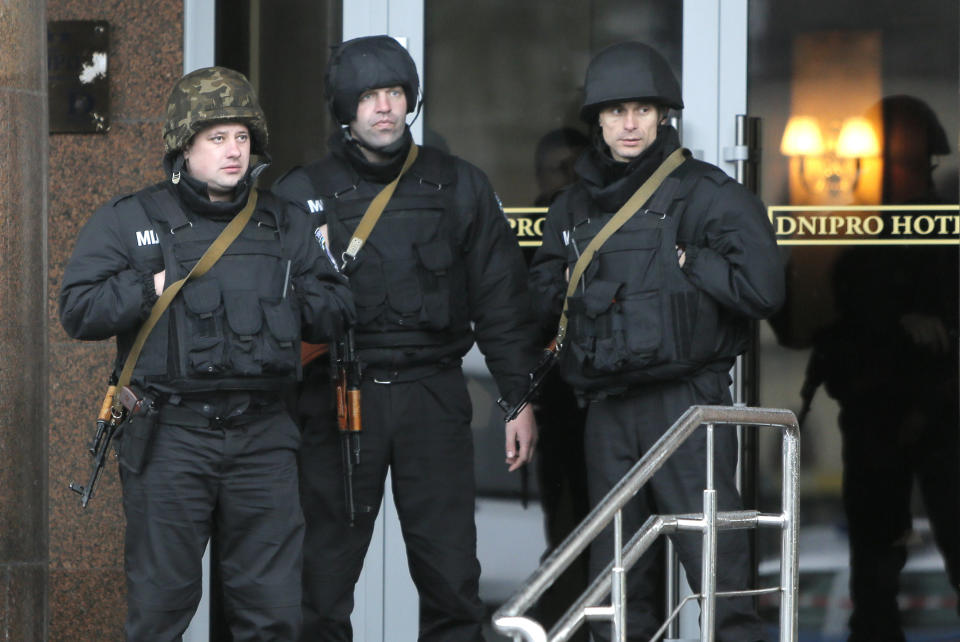 Riot police officers guard entrance in the Hotel Dnipro in Kiev, Ukraine, Tuesday, April 1, 2014. A tense standoff between Ukrainian police and a radical nationalist group Right Sector ended Tuesday, when its members surrendered their weapons and left a downtown hotel. Their departure followed a shooting spree in the capital, in which a Right Sector member shot and wounded three people outside a restaurant adjacent to the capital’s main Independence Square, including a deputy mayor of the capital. (AP Photo/Efrem Lukatsky)