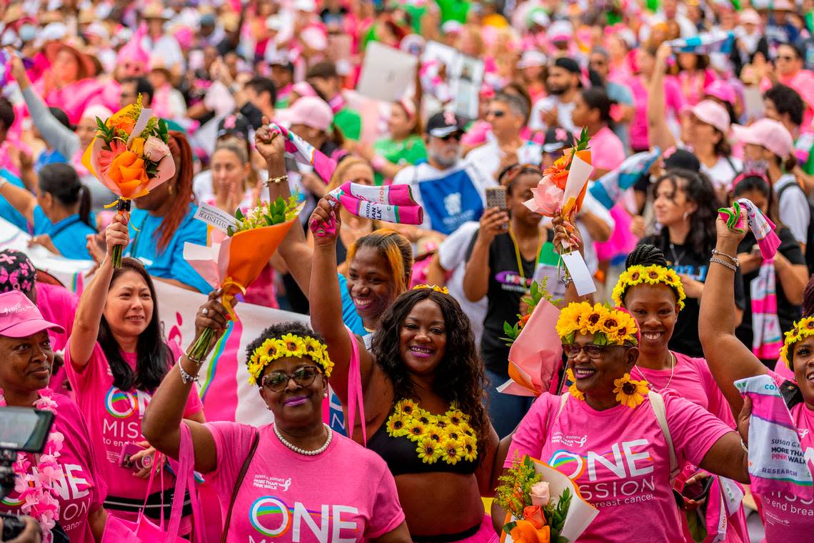 Breast cancer survivors hold flowers and cheer as they attend the Susan G. Komen More Than Pink Walk at Amelia Earhart Park on Saturday, Oct. 8, 2022, in Hialeah, Fla. The event aims to raise awareness and money for breast cancer research.