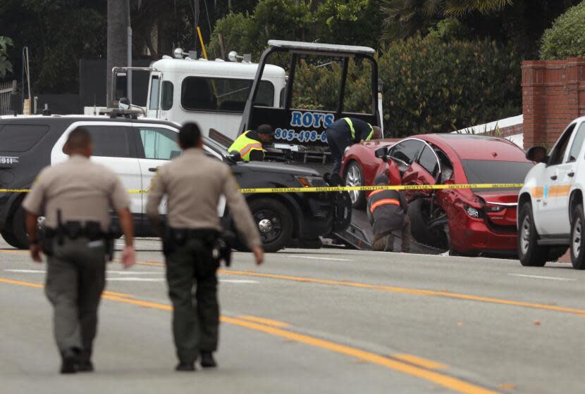 LOS ANGELES, CA - OCTOBER 18, 2023 - Sheriff deputies approach the scene where four women were killed in a multi-vehicle crash in Malibu on October 18, 2023. A 22-year-old man was arrested after plowing into the pedestrians and parked cars. The crash was reported at 8:30 p.m. Tuesday in the 21600 block of Pacific Coast Highway where they found the victims of the crash, along with the severely damaged vehicles. The crash began when the suspect lost control of his BMW and slammed into multiple parked cars before ricocheting and fatally striking the women, who were standing on the side of the road. (Genaro Molina / Los Angeles Times)