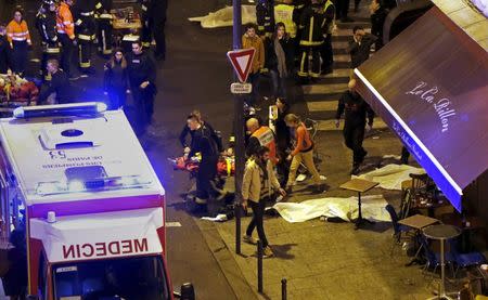 General view of the scene with rescue service personnel working near covered bodies outside a restaurant following shooting incidents in Paris, France, November 13, 2015. REUTERS/Philippe Wojazer