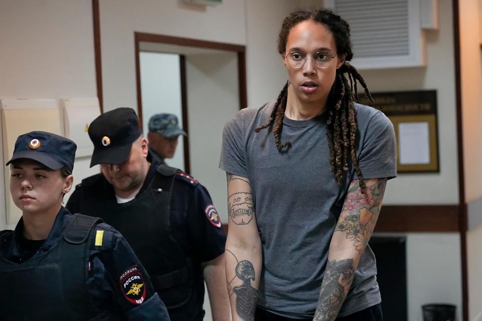 Brittney Griner is escorted from a courtroom after a hearing in Khimki just outside Moscow, on Aug. 4, 2022. The WNBA star, seen in this photo with her signature locs, cut her hair during her imprisonment at the Mordovia penal colony due to the brutal winter temperatures.