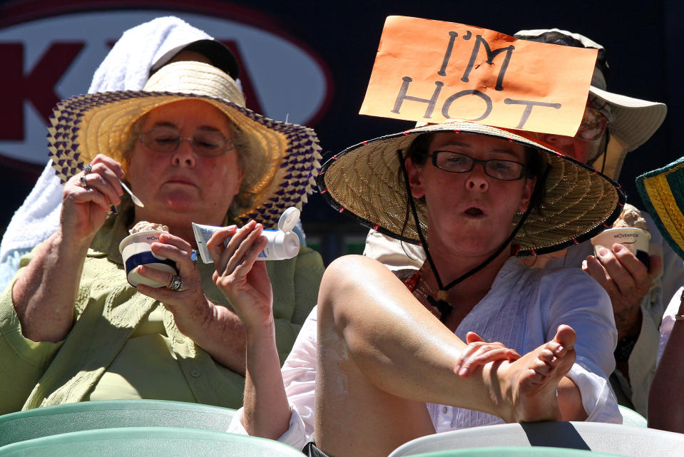 FILE - In this Jan. 28, 2009, file photo, a spectator applies sun cream while others eat ice cream as they try to keep cool in the scorching heat on Rod Laver Arena at the Australian Open tennis tournament in Melbourne, Australia. Top climate scientists are gathering in Japan this week to finish up a report on the impact of global warming. And they say if you think climate change is only faced by some far-off polar bear decades from now, well, you’re mistaken. They say the dangers of a warming Earth are immediate and human. The report says risks from warming-related extreme weather are at the moderate level now, but are likely to become high with just a bit more warming. While it doesn’t say events were caused by climate change, the report mentions heat waves in Australia. (AP Photo/Rick Stevens, File)