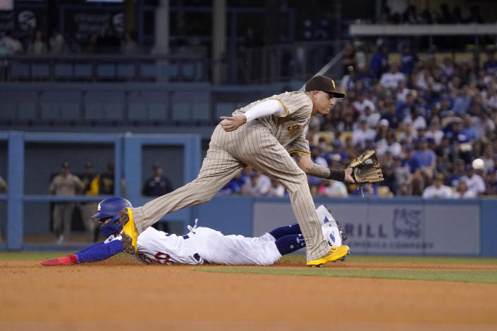Los Angeles Dodgers' Mookie Betts, left, steals second as San Diego Padres third baseman Manny Machado takes a late throw during the fifth inning of a baseball game Saturday, Aug. 6, 2022, in Los Angeles. (AP Photo/Mark J. Terrill)