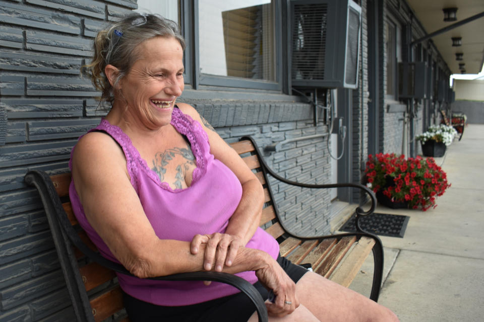 Dana Amon speaks about trucks hauling crude oil through McKenzie County as she sits in front of the McKenzie Inn, Aug. 26, 2021, in Watford City, N.D. Amon, who grew up in a double-wide trailer on a farm on the edge of the county seat, Watford City, remembers riding her horse across fields now dotted with tracts of modest housing lit up at night by the flares from nearby oil wells. “Our little town just blew up at the seams,” she said. (AP Photo/Matthew Brown)