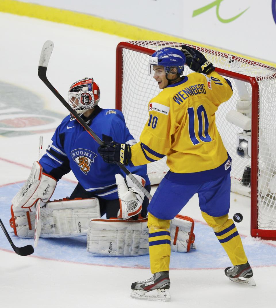 Sweden's Alexander Wennberg (R) celebrates a goal by teammate Lucas Wallmark, not seen, on Finland's goalie Juuse Saros during the second period of their IIHF World Junior Championship gold medal ice hockey game in Malmo, Sweden, January 5, 2014. REUTERS/Alexander Demianchuk (SWEDEN - Tags: SPORT ICE HOCKEY)