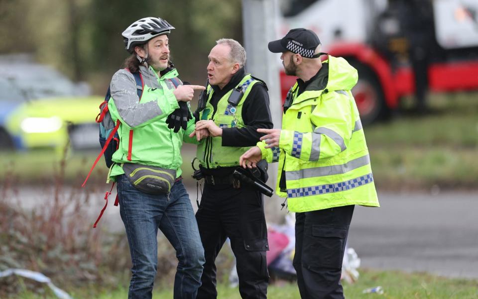A man is arrested for breach of the peace after trying to get closer to the scene and friends laying flowers as a vehicle is recovered - Gareth Everett