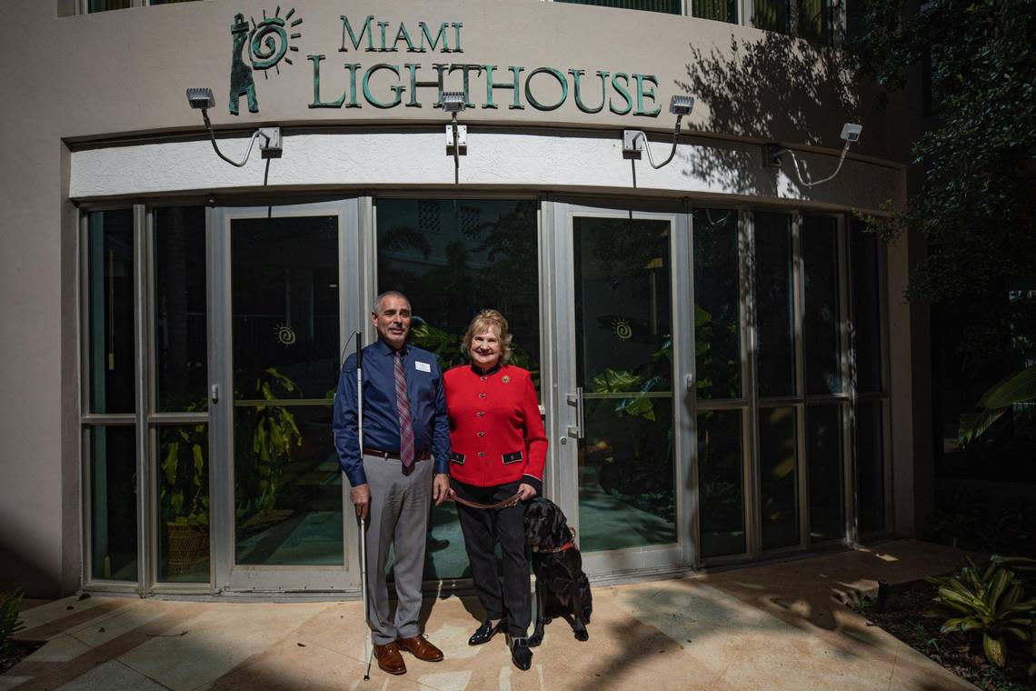 Manager of Technology Jorge Hernandez and President and CEO Virginia Jacko and her guide dog, Brava, pose for a portrait at Miami Lighthouse for the Blind and Visually Impaired on Oct. 13, 2022.