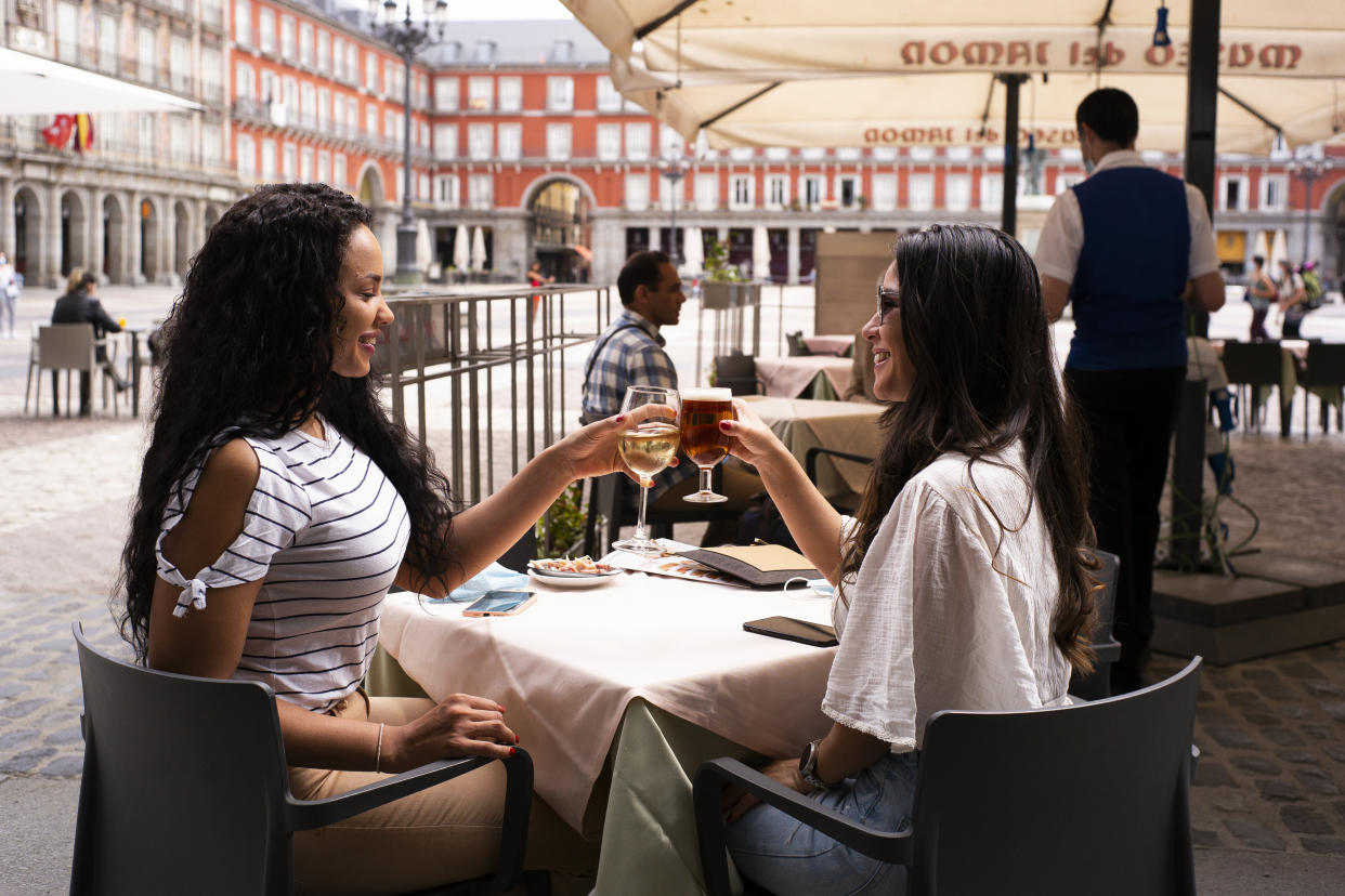 Customers sit at tables socially distanced from each other at the outdoor terrace of a bar, operating at reduced capacity in Plaza Mayor  to open after 9 weeks of severe lockdown by Covid-19 on May 26, 2020 in Madrid, Spain. The regions of Madrid as well as the metropolitan area of Barcelona entered Phase 1, which allows sidewalk cafes to reopen at 50% capacity  (Photo by Oscar Gonzalez/NurPhoto via Getty Images)