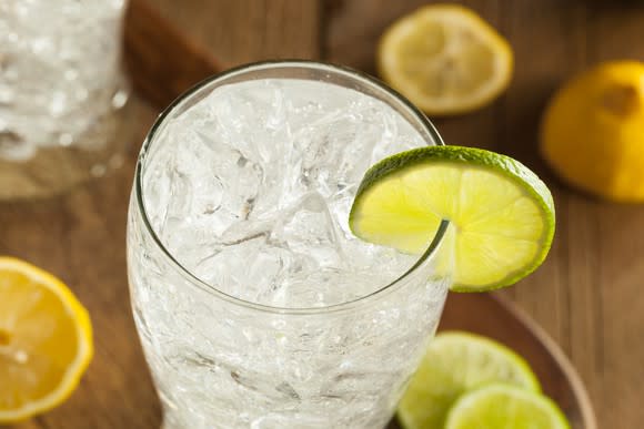 A glass of soda water garnished with a lime.