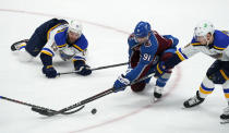 Colorado Avalanche center Nazem Kadri, centyer, fights for control of the puck with St. Louis Blues left wing Kyle Clifford, left, and center Ivan Barbashev in the first period of an NHL hockey game Friday, Jan. 15, 2021, in Denver. (AP Photo/David Zalubowski)