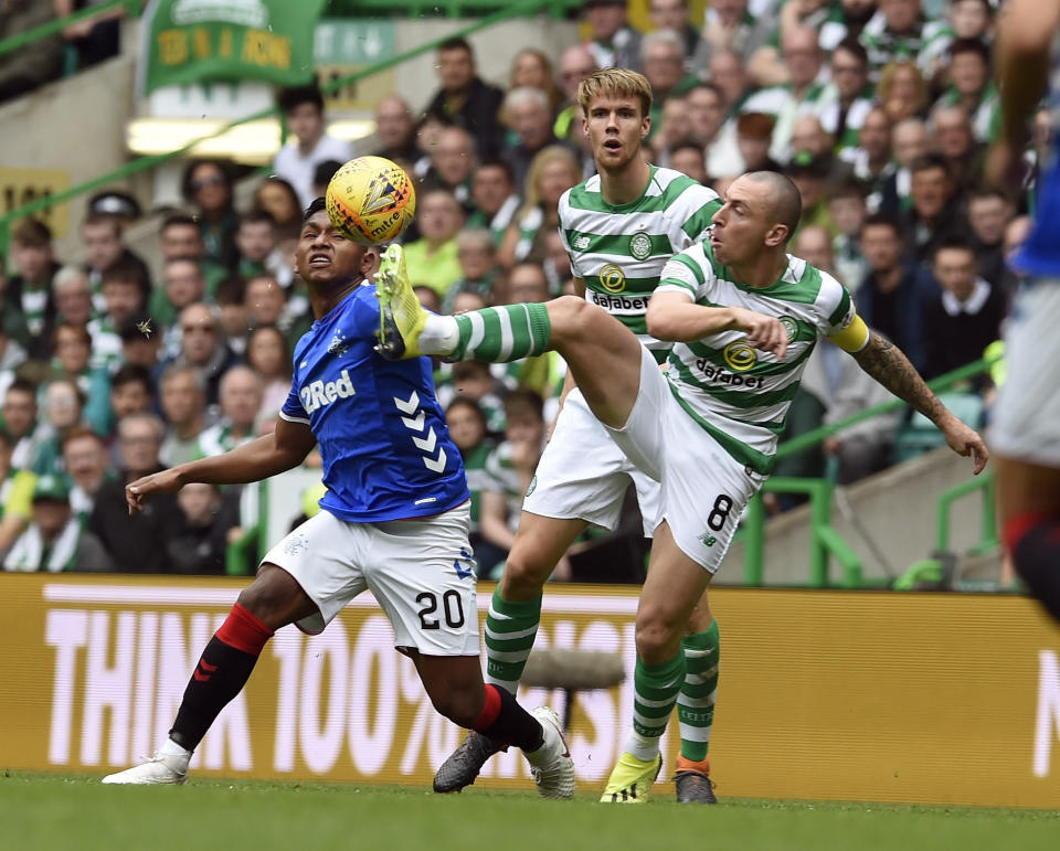 Rangers' Alfredo Morelos, left and Celtic's Scott Brown battle for the ball, during the Scottish Premiership soccer match between Celtic and Rangers, at Celtic Park, in Glasgow, Scotland, Sunday, Sept. 2, 2018. (Ian Rutherford/PA via AP)