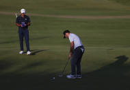 South Africa's Louis Oosthuizen, right, puts watched by g4 on the 18th green during the third round of the British Open Golf Championship at Royal St George's golf course Sandwich, England, Saturday, July 17, 2021. (AP Photo/Ian Walton)