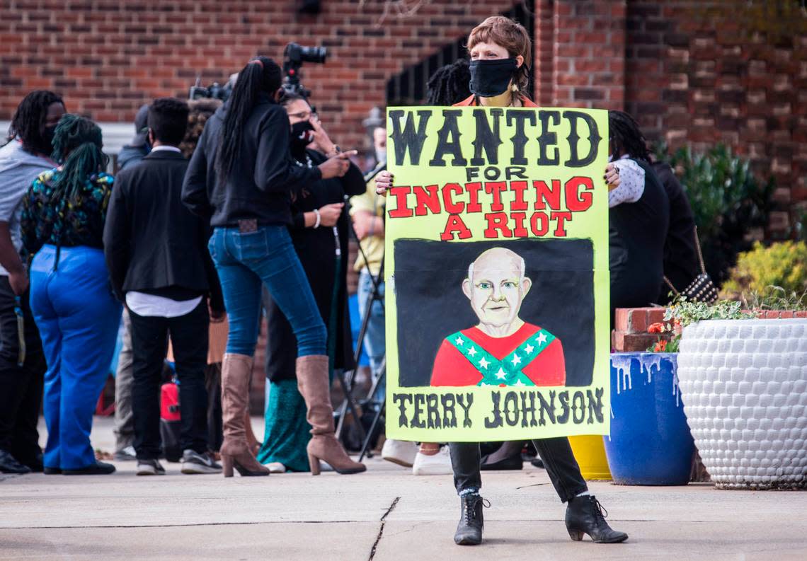 A woman who declined to give her name holds a sign referencing Alamance County Sheriff Terry Johnson in downtown Graham before a press conference on Nov. 22, 2020.
