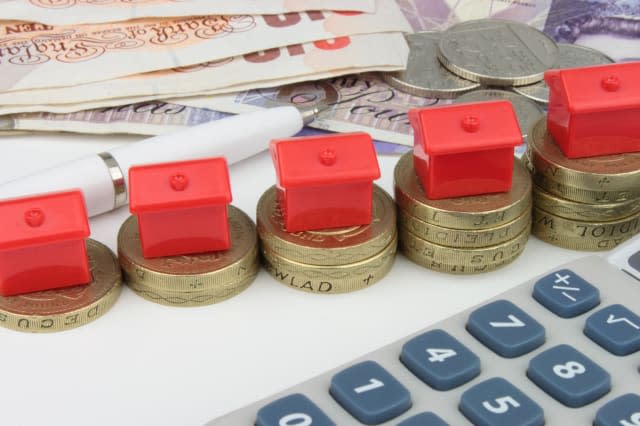 a red houses sitting on a coins ...