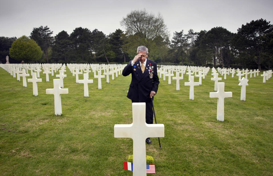 In this May 1, 2019 file photo, World War II and D-Day veteran Charles Norman Shay, from Indian Island, Maine, salutes the grave of fellow soldier Edward Morozewicz at the Normandy American Cemetery in Colleville-sur-Mer, Normandy, France. Instead of parades, remembrances, embraces and one last great hurrah for veteran soldiers who are mostly in their nineties to celebrate VE Day, it is instead a lockdown due to the coronavirus, COVID-19. (AP Photo/Virginia Mayo, File)