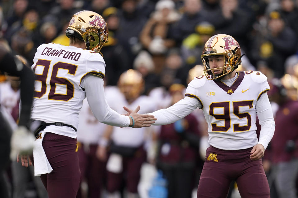 Minnesota place kicker Matthew Trickett (95) celebrates with teammate Mark Crawford (96) after kicking a 20-yard field goal during the first half of an NCAA college football game against Iowa, Saturday, Nov. 13, 2021, in Iowa City, Iowa. (AP Photo/Charlie Neibergall)