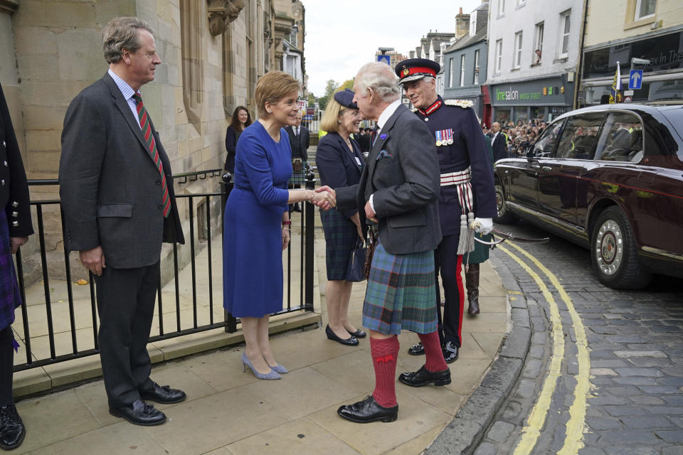 Britain's King Charles III shakes hands with Scottish First Minister Nicola Sturgeon as Scottish Secretary Alister Jack, left, looks on, as he arrives at the City Chambers in Dunfermline, Fife, to formally mark the conferral of city status on the former town. (Andrew Milligan/PA via AP)