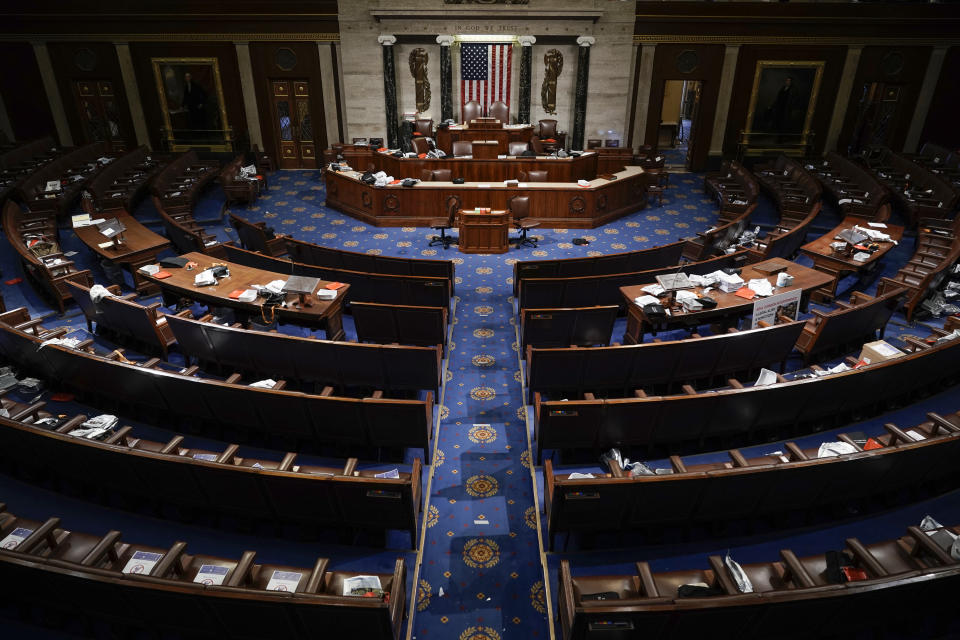FILE - Papers and gas masks are left behind after House of Representatives members left the floor of the House chamber as rioters try to break into the chamber at the U.S. Capitol on Jan. 6, 2021, in Washington. (AP Photo/J. Scott Applewhite, File)