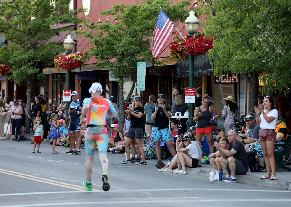 The crowd cheers as a man runs by them during an Ironman