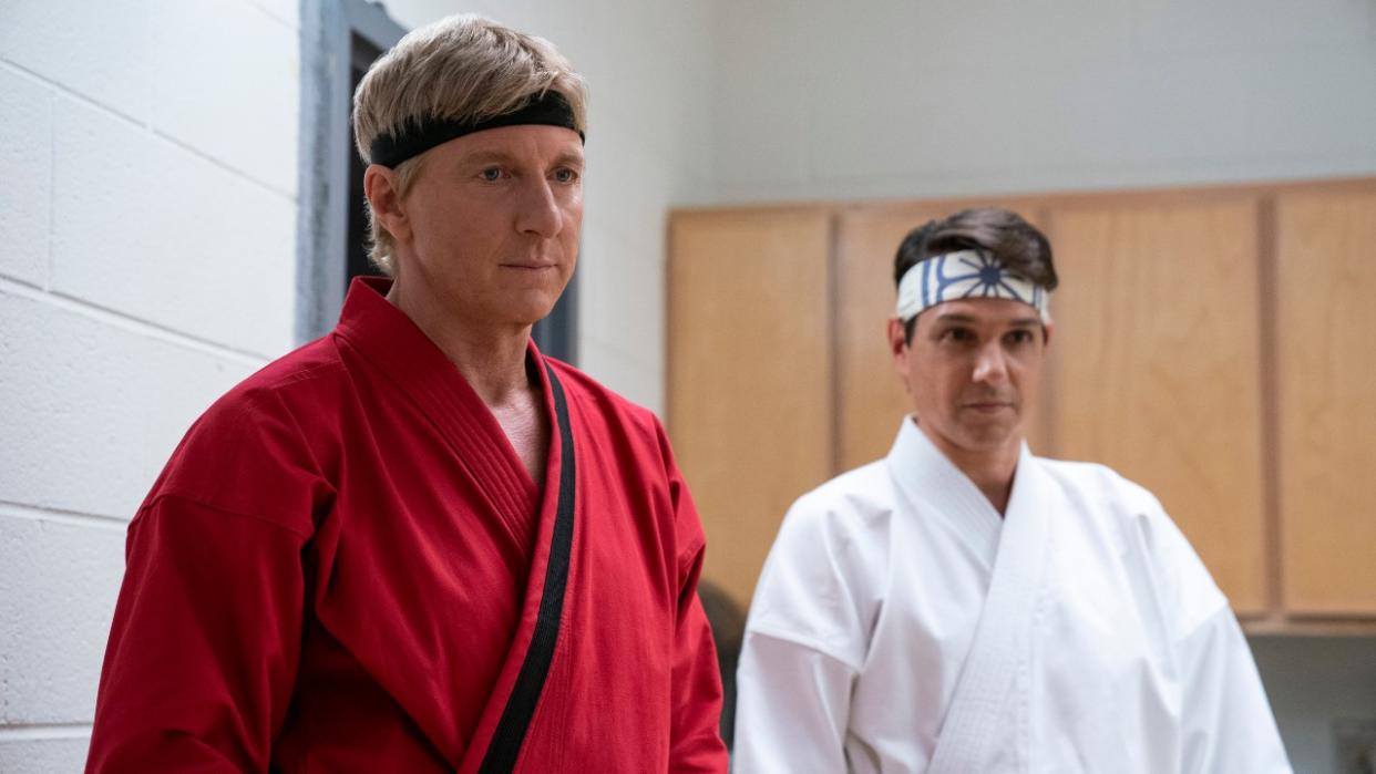  William Zabka and Ralph Macchio in red and white karate uniforms respectively 