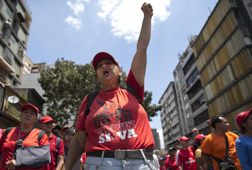 A member of the Bolivarian Militia, wearing a shirt that reads in Spanish "Yes, Chavez stays," yells during a meeting by milita members outside Miraflores presidential palace in Caracas, Venezuela, Tuesday, March 12, 2019. Members of the militia, which were formed the late President Hugo Chavez, met to show support for embattled President Nicolas Maduro after nearly a week of national blackouts while their country reels from economic and political calamity. (AP Photo/Ariana Cubillos)