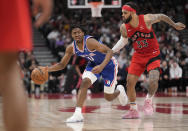 Philadelphia 76ers guard Tyrese Maxey (0) controls the ball as Toronto Raptors guard Gary Trent Jr. (33) defends during the second half of an NBA basketball game Thursday, April 7, 2022, in Toronto. (Frank Gunn/The Canadian Press via AP)