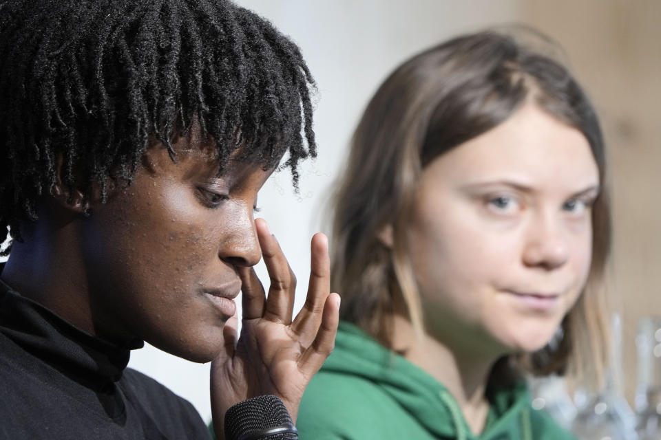 Climate activist Vanessa Nakate of Uganda, left, reacts beside Greta Thunberg of Sweden at a press conference at the World Economic Forum in Davos, Switzerland Thursday, Jan. 19, 2023. The annual meeting of the World Economic Forum is taking place in Davos from Jan. 16 until Jan. 20, 2023. (AP Photo/Markus Schreiber)