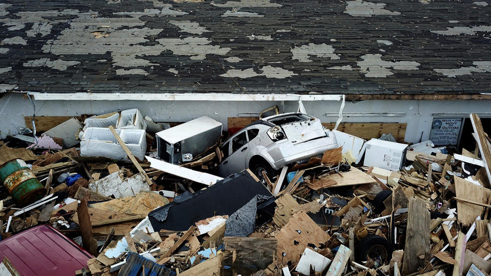 A car lays among debris from homes flattened by Hurricane Dorian in an area called "The Mud" at Marsh Harbour in Great Abaco Island, Bahamas on Thursday, Sept. 5, 2019. (Al Diaz/Miami Herald via AP)