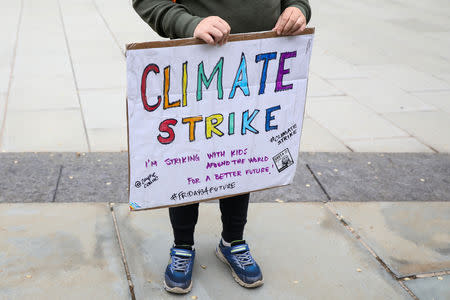 FILE PHOTO: An attendant holds a placard during a protest to call for urgent action to slow the pace of climate change in New York, U.S., May 3, 2019. REUTERS/Brendan McDermid/File Photo