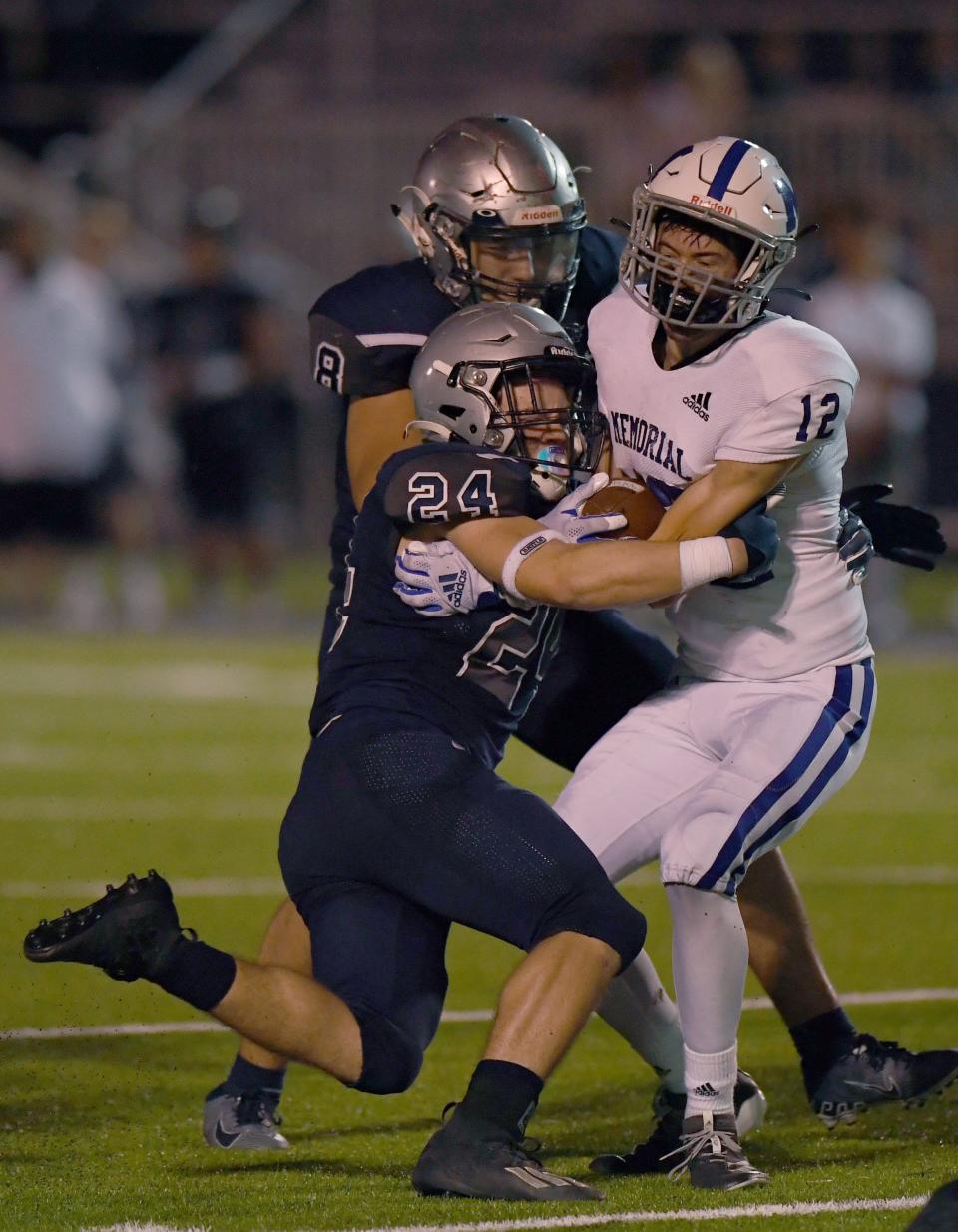 Reitz's Ayden Wells (24) tackles Memorial's Hugh Pearce (12) as the Memorial Tigers take on the Reitz Panthers at the Reitz Bowl in Evansville, Ind., Friday evening, Oct. 1, 2021. 