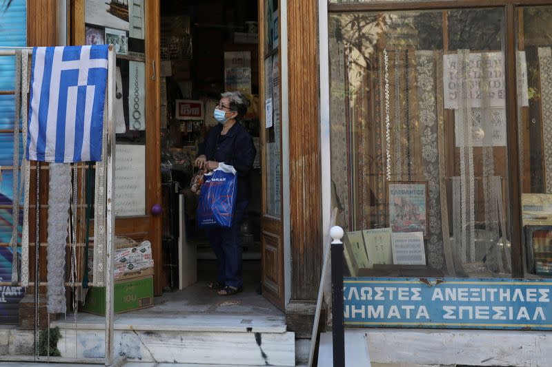 A woman wearing a protective face mask is seen inside a store, amid the spread of the coronavirus disease (COVID-19), in Athens
