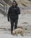 <p>Hugh Jackman bundles up to walk his dog on the beach in The Hamptons, New York, on Monday.</p>