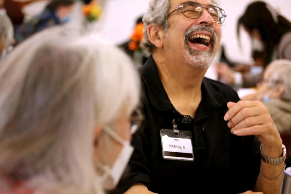 A man laughs while sitting next to a woman