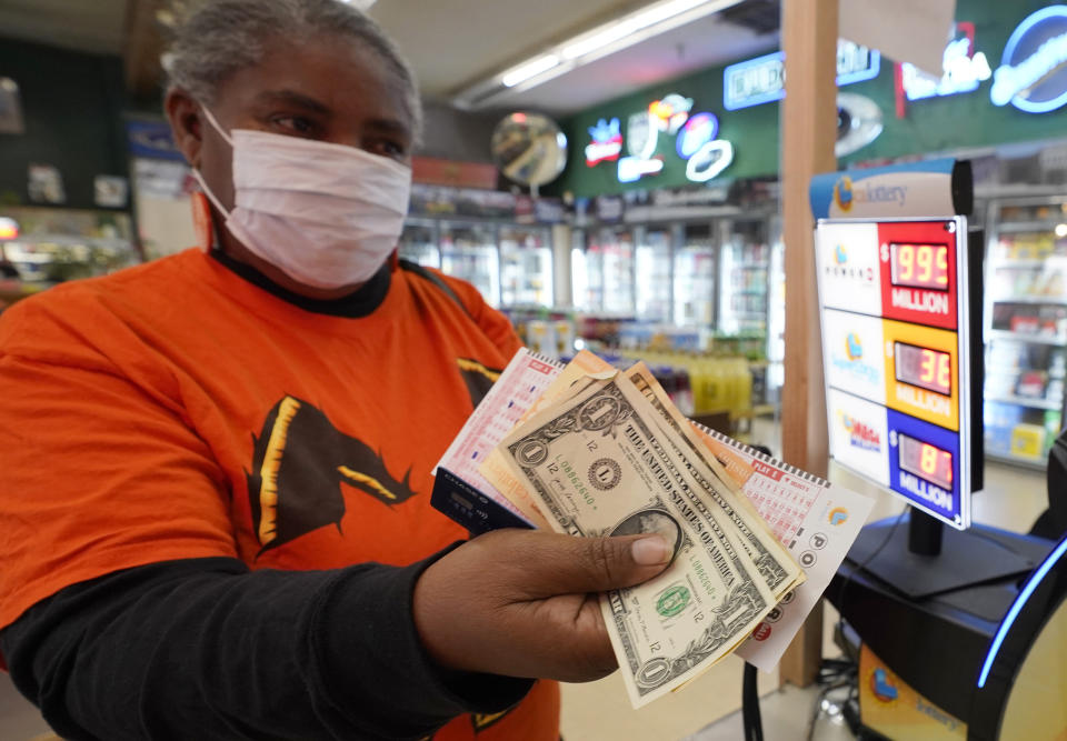 Deborah Hearne, purchase's Powerball lottery tickets at Lichine's Liquor & Deli in Sacramento, Calif., Monday, Oct. 31, 2022. The jackpot for Monday night's drawing soared to $1 billion after no one matched all six numbers in Saturday night's drawing. It's the fifth-largest lottery jackpot in U.S. history. (AP Photo/Rich Pedroncelli)