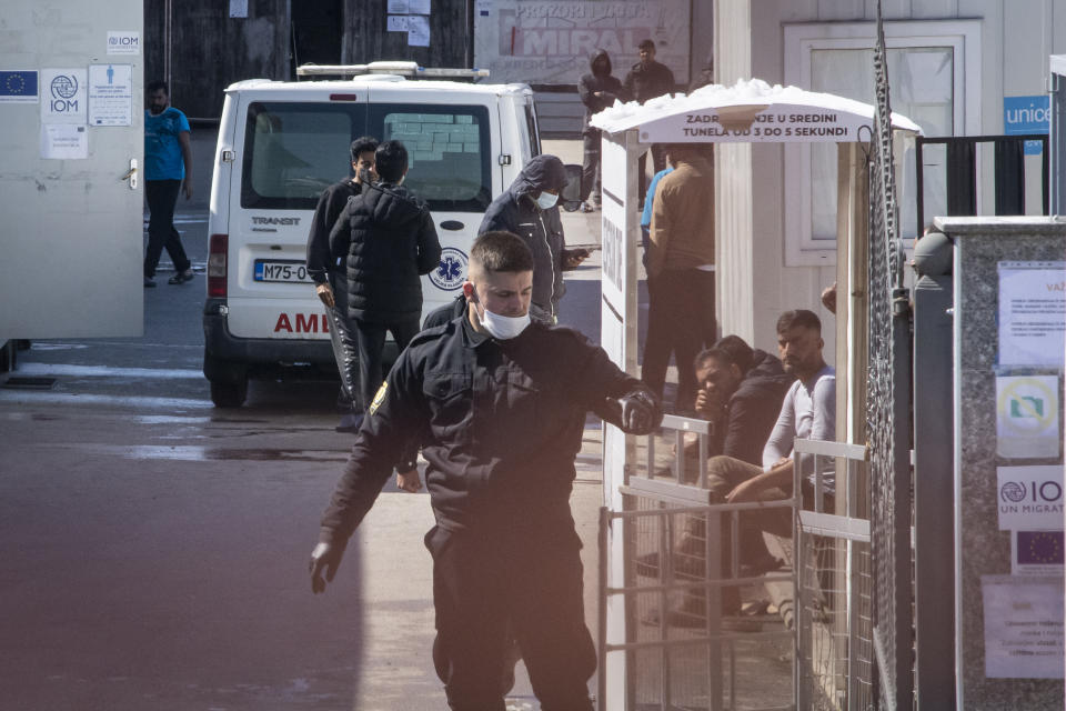 A police officer stands outside the the Miral migrants camp, in Velika Kladusa, Bosnia, Wednesday, April 7, 2021. Bosnia is seeing a rise in coronavirus infections among migrants and refugees living in its camps, as it struggles to cope with one of the Balkans' highest COVID-19 death and infection rates among the general population.(AP Photo/Davor Midzic)