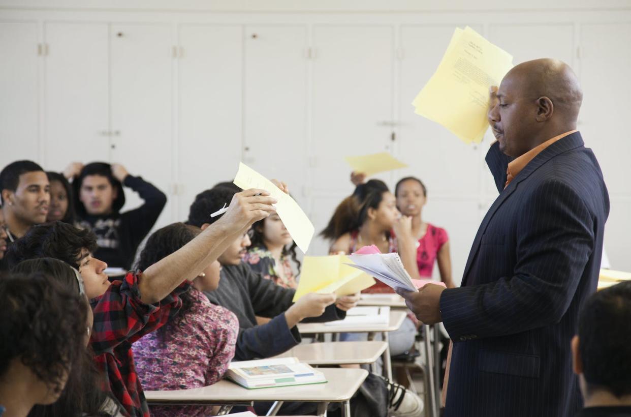 Lawmakers have passed many laws that seek to control how teachers educate students about racism in the U.S. <a href="https://www.gettyimages.com/detail/photo/teacher-holding-papers-in-classroom-royalty-free-image/103056390?adppopup=true" rel="nofollow noopener" target="_blank" data-ylk="slk:Hill Street Studios / Getty Images;elm:context_link;itc:0;sec:content-canvas" class="link ">Hill Street Studios / Getty Images</a>