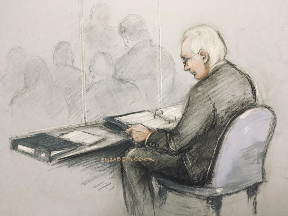 This is a court artist sketch of Wikileaks founder Julian Assange in the dock reading his papers as he appears at Belmarsh Magistrates' Court for his extradition hearing, in London, Monday, Feb. 24, 2020. The U.S. government and WikiLeaks founder Julian Assange will face off Monday in a high-security London courthouse, a decade after WikiLeaks infuriated American officials by publishing a trove of classified military documents. (Elizabeth Cook/PA via AP)