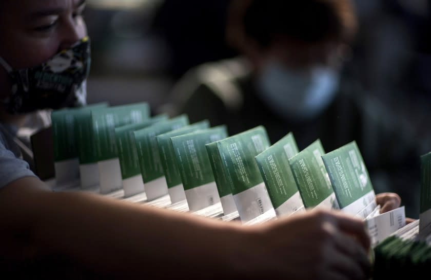 An election inspector checks the names of voters as the counting of ballots begins on Election Day at City Hall