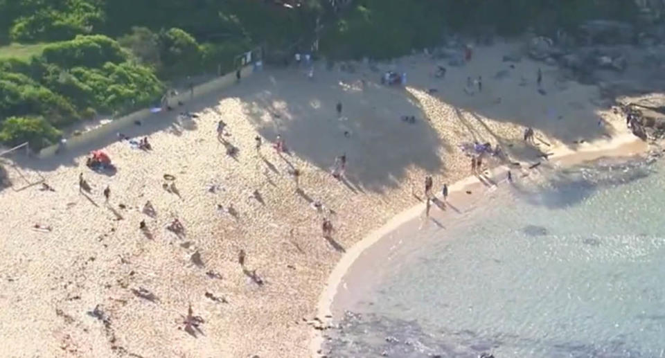 Beachgoers in an aerial shot of Little Bay Beach.