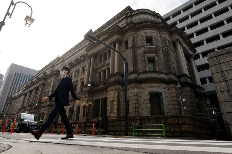 FILE PHOTO: A man walks in front of the headquarters of Bank of Japan in Tokyo