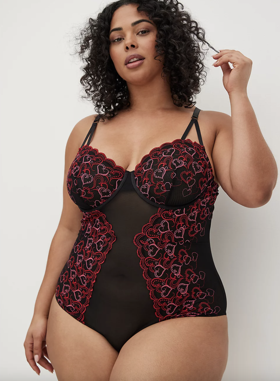 plus size model in black and heart Torrid Embroidered Hearts Bodysuit (Photo via Torrid)