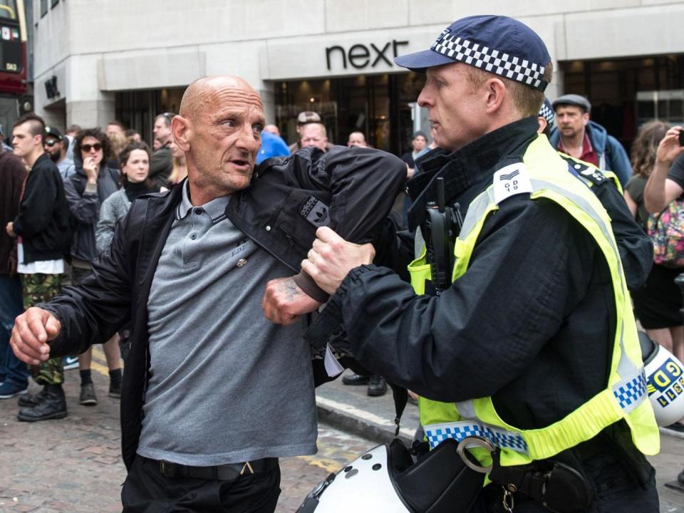 A police officer scuffles with a man as members of the far-right anti-immigration English Defence League (EDL) march from Victoria Embankment to Charing Cross Station under heavy police guard, in London (EPA/PETE MACLAINE)