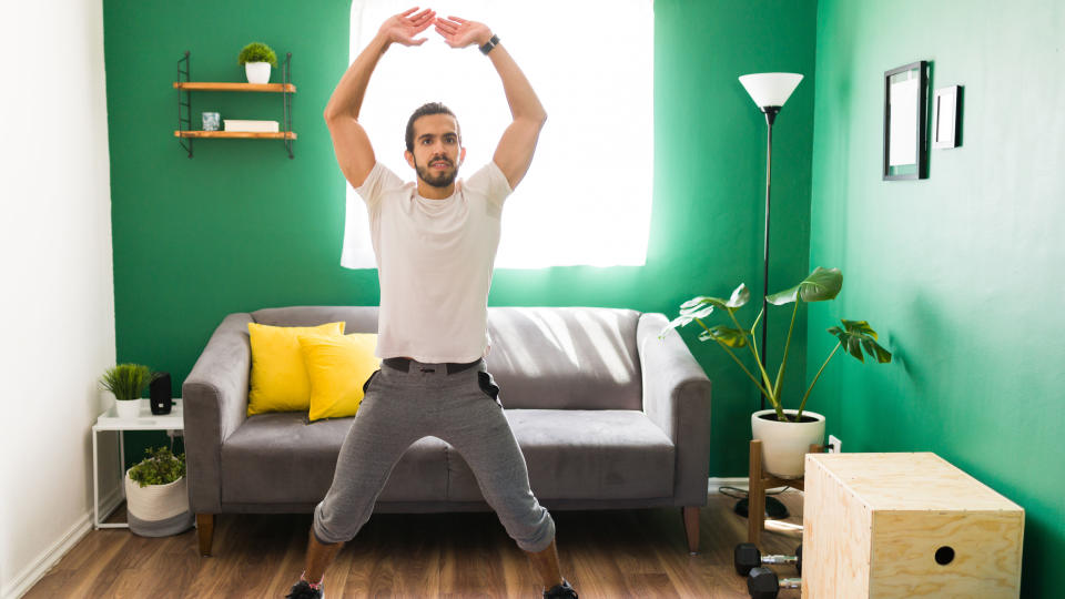 Man doing jumping jacks at home