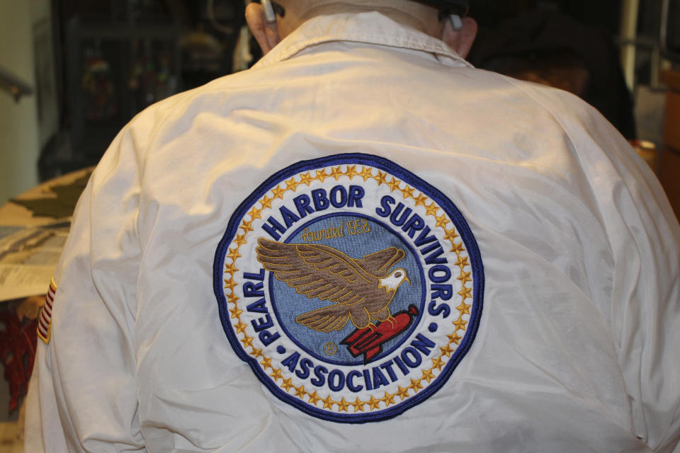 Ira "Ike" Schab, 103, shows the back of his shirt, which reads "Pearl Harbor Survivors Association," while sitting at the kitchen table in his home in Beaverton, Ore. on Monday, Nov. 20, 2023. Schab was in the Navy and on the USS Dobbin during the Pearl Harbor attacks on Dec. 7, 1941. Eighty-two years later, Schab plans to return to Pearl Harbor on the anniversary of the attack to remember the more than 2,300 servicemen killed. (AP Photo/Claire Rush)