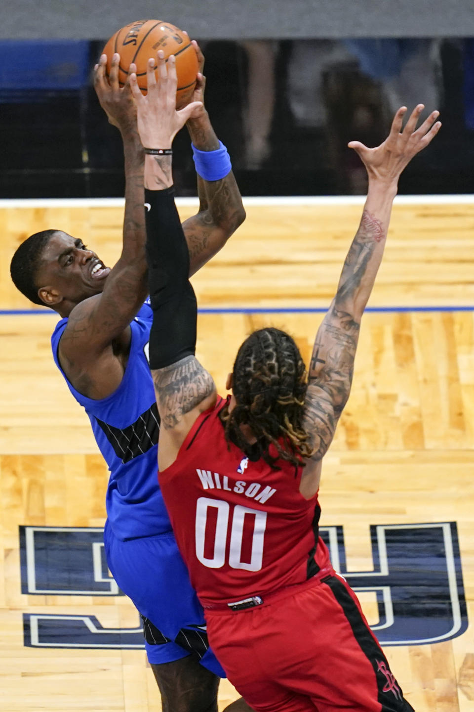 Orlando Magic guard Dwayne Bacon, left, makes a shot over Houston Rockets forward D.J. Wilson (00) during the second half of an NBA basketball game, Sunday, April 18, 2021, in Orlando, Fla. (AP Photo/John Raoux)