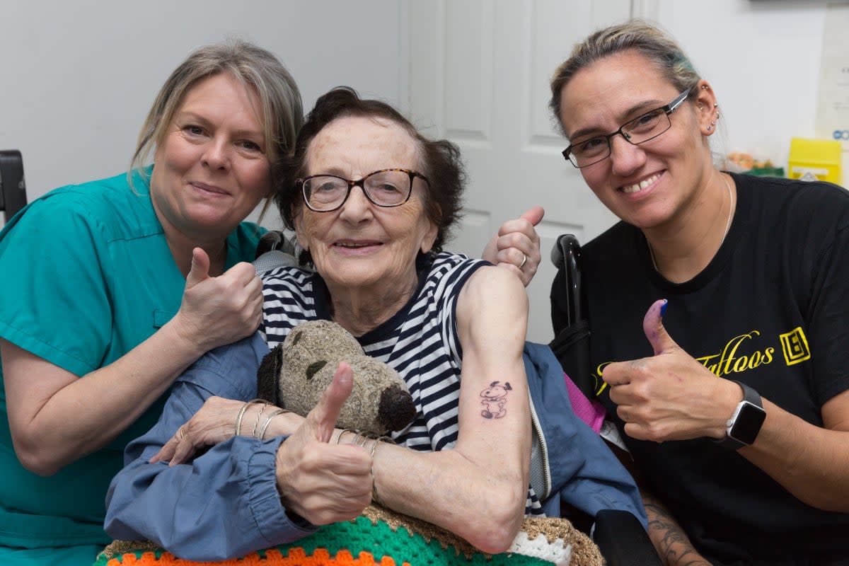 Dorothy France (centre), a resident at Care UK's The Burroughs in London, has fulfilled her teenage dream after getting her first tattoo of Snoopy (Andrew H Williams/Care UK/PA Wire)