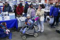 A child sits in a stroller holding an electronic item at a Best Buy store in Westbury, New York November 28, 2014. REUTERS/Shannon Stapleton