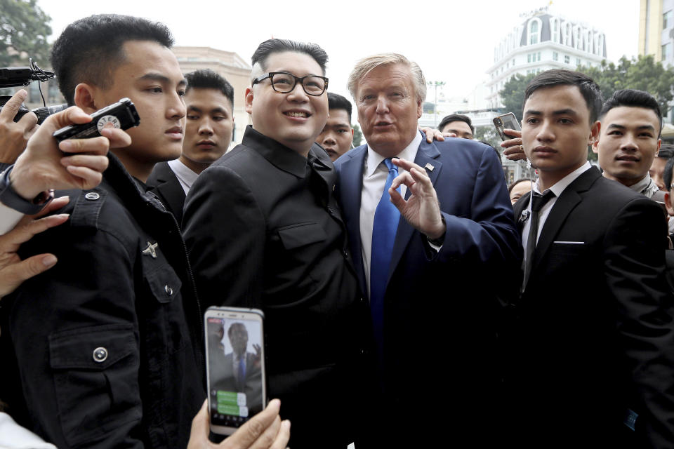 U.S. Donald Trump impersonator Russell White, two right, and North Korea leader Kim Jong-un impersonator Howard X, second left, pose for photos outside the Opera House in Hanoi, Vietnam, Friday, Feb. 22, 2019. The second summit between Trump and Kim will take place in Hanoi on Feb. 27 and 28. (AP Photo/Minh Hoang)