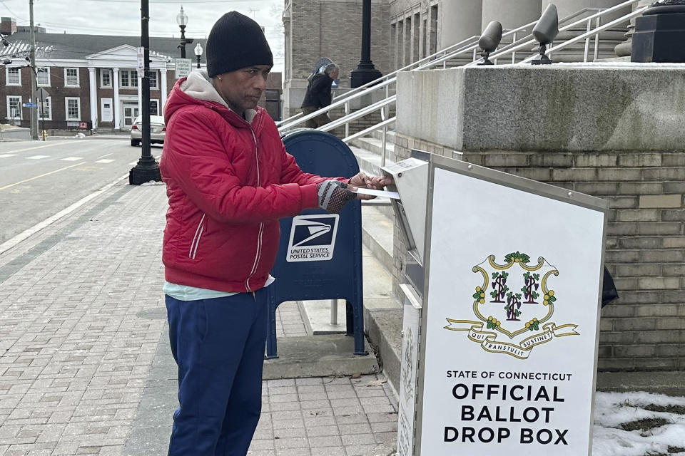 Manuel Alcantara deposits absentee ballots for his son and daughter in a dropbox outside City Hall in Bridgeport, Conn., Wednesday, Feb. 21, 2024. He wanted to make sure they were properly deposited because he's had issues with campaign workers coming to his home, wanting to pick them up. Tuesday's general election marks the fourth time Democrats will have voted for the next mayor - counting the two primaries and two general elections - since the now-voided Sept. 12 primary when incumbent Mayor Joe Ganim defeated challenger John Gomes by 251 votes out of 8,173 cast. It will be the second time for Republicans and unaffiliated voters. (AP Photo/Susan Haigh)